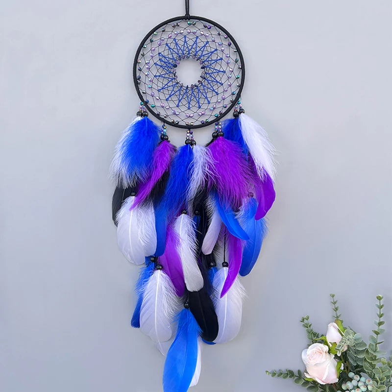 Dreamcatcher with blue, purple, and white feathers on a light gray background