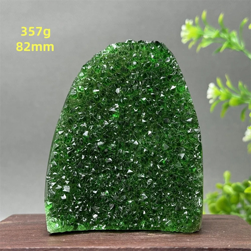Green crystal rock on a wooden surface with a gray background