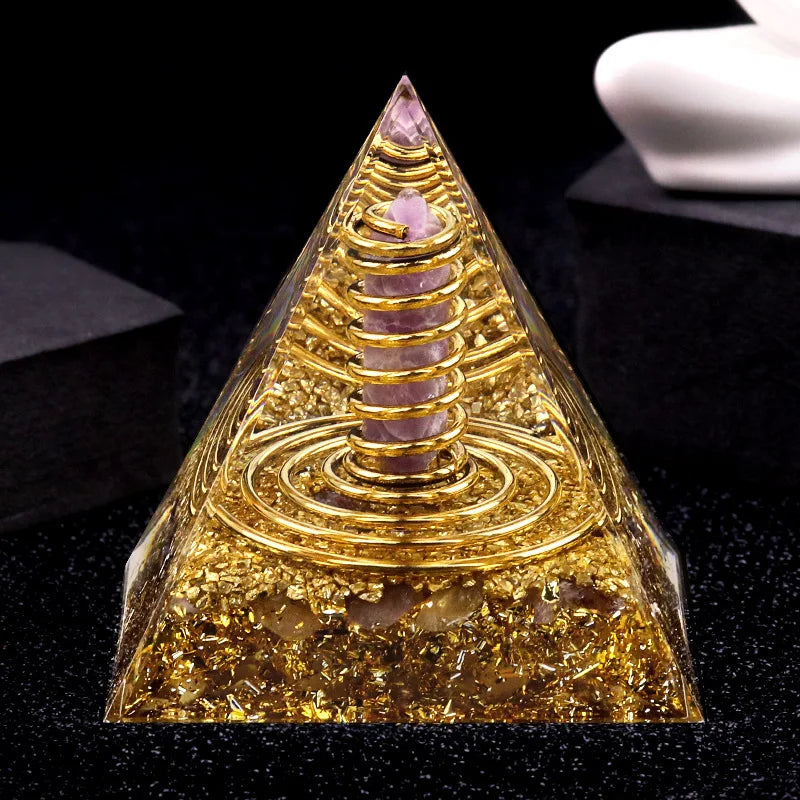 Decorative pyramid with gold spiral and pink stones on a black background
