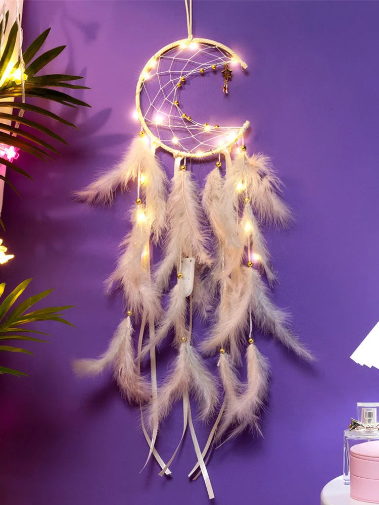 Decorative dreamcatcher with feathers and lights on a purple wall