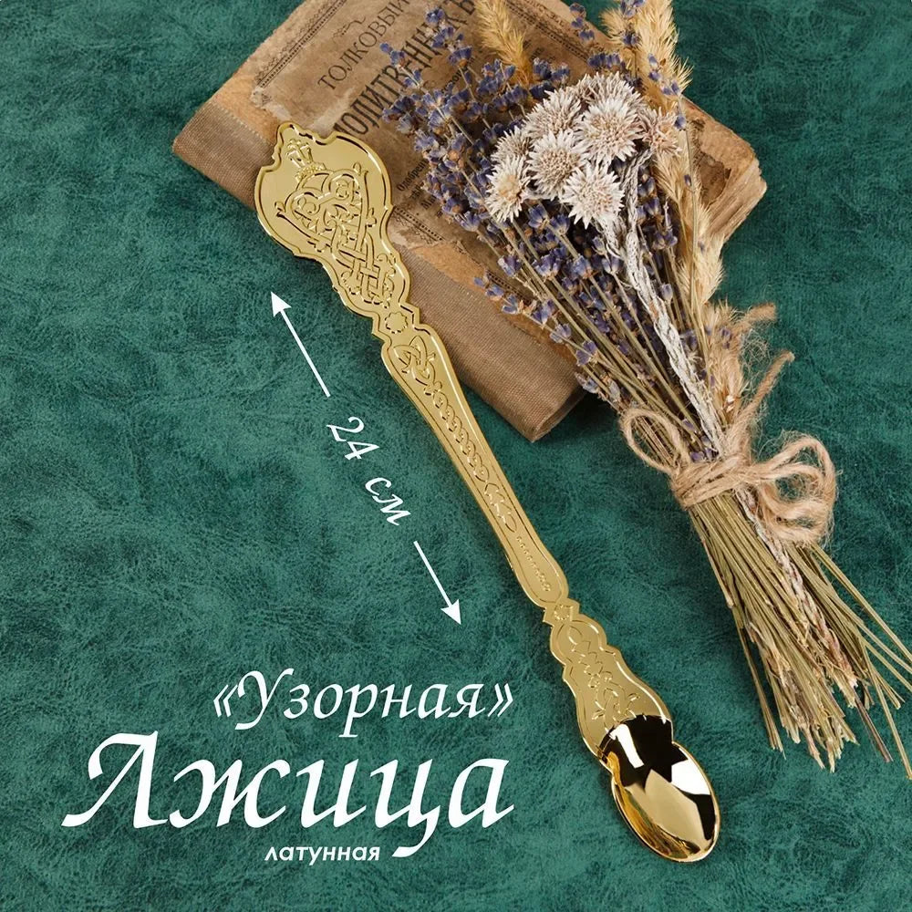 Decorative gold spoon with a bouquet of dried lavender on a textured green background