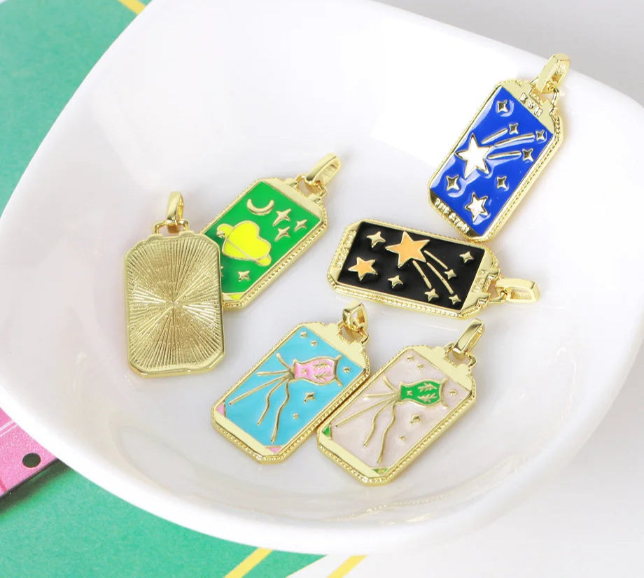 Colorful pendant collection on a white plate with 'Crista' branding.