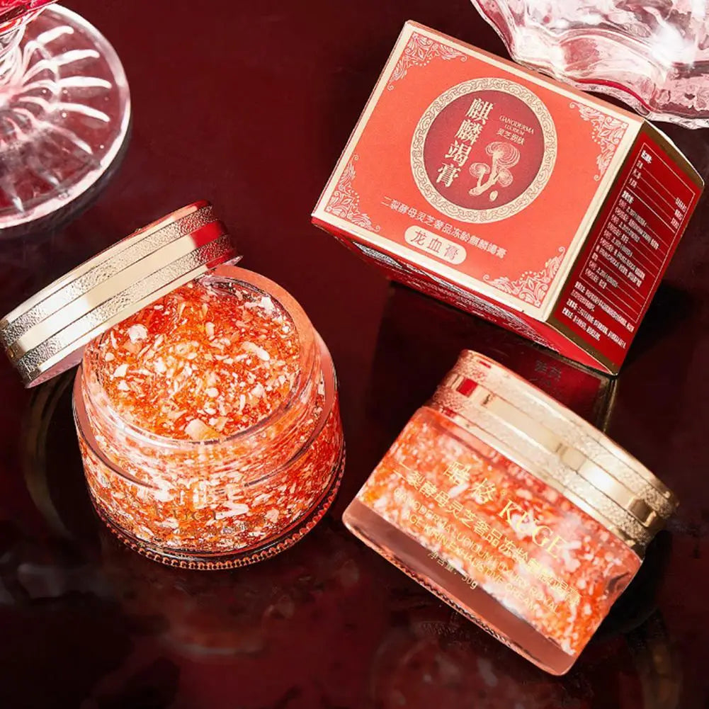 Two jars of red powder with a red box on a dark surface