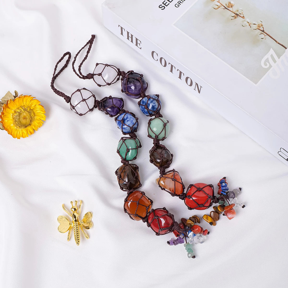 Colorful beaded necklace on a white surface with a magazine underneath