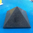 Black pyramid-shaped object on a blue surface