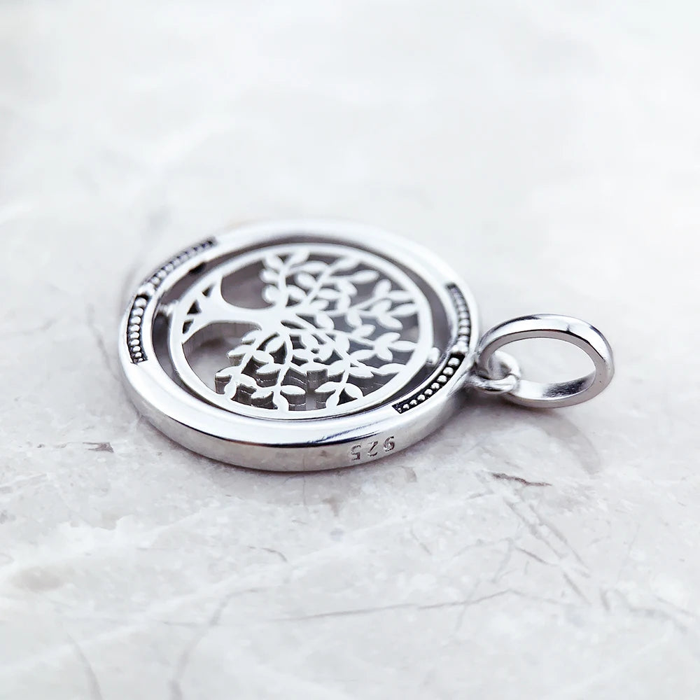 Silver pendant with tree design on a white background