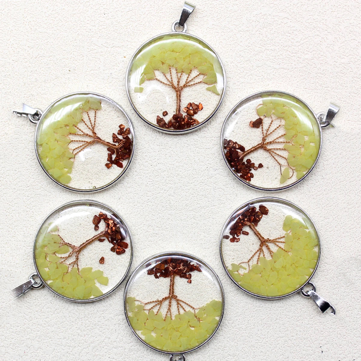 Six circular pendants with tree designs on a white background