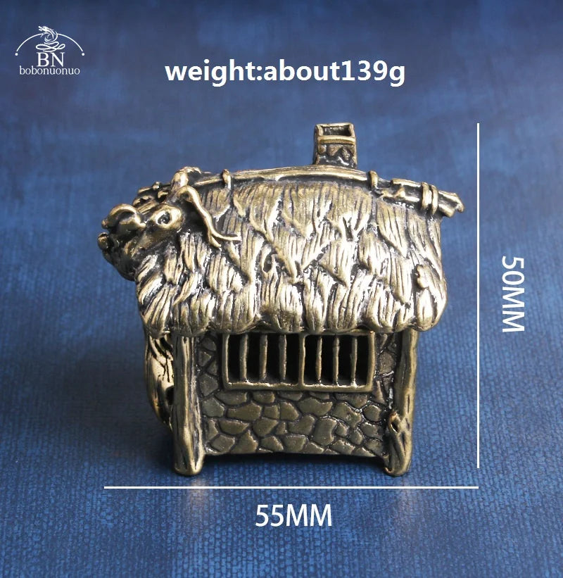 Bronze-colored miniature house figurine with measurements on a blue background