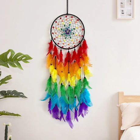 Colorful dreamcatcher hanging on a wall with a bed and plant in the background