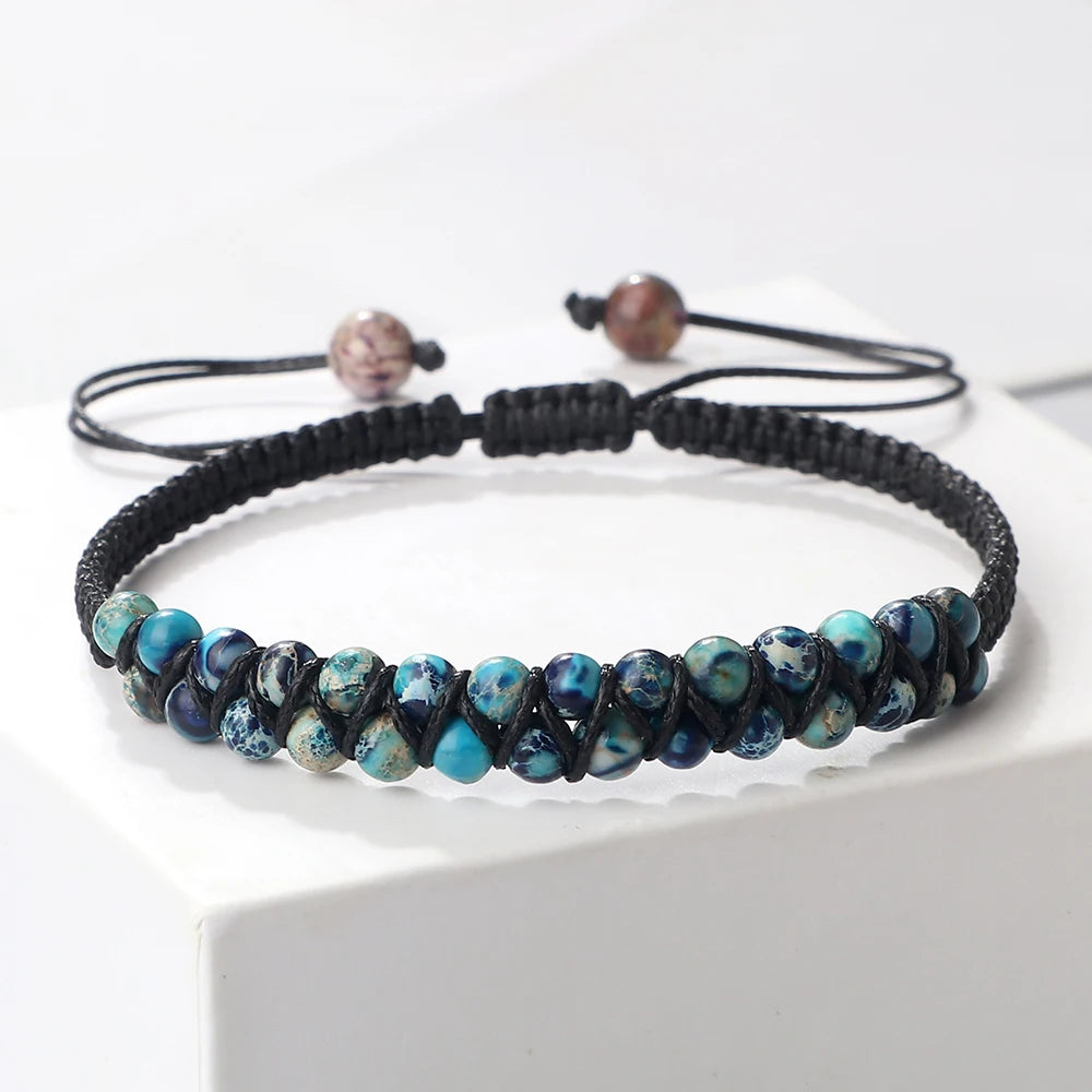 Black braided bracelet with blue beads on a white surface