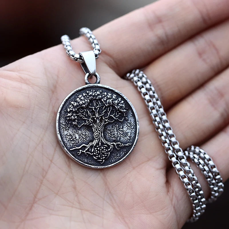 Silver tree pendant necklace on a hand