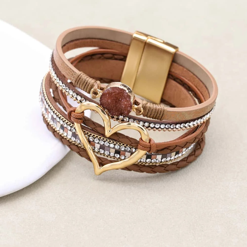 Multistrand leather bracelet with gold heart charm and magnetic clasp on a light background