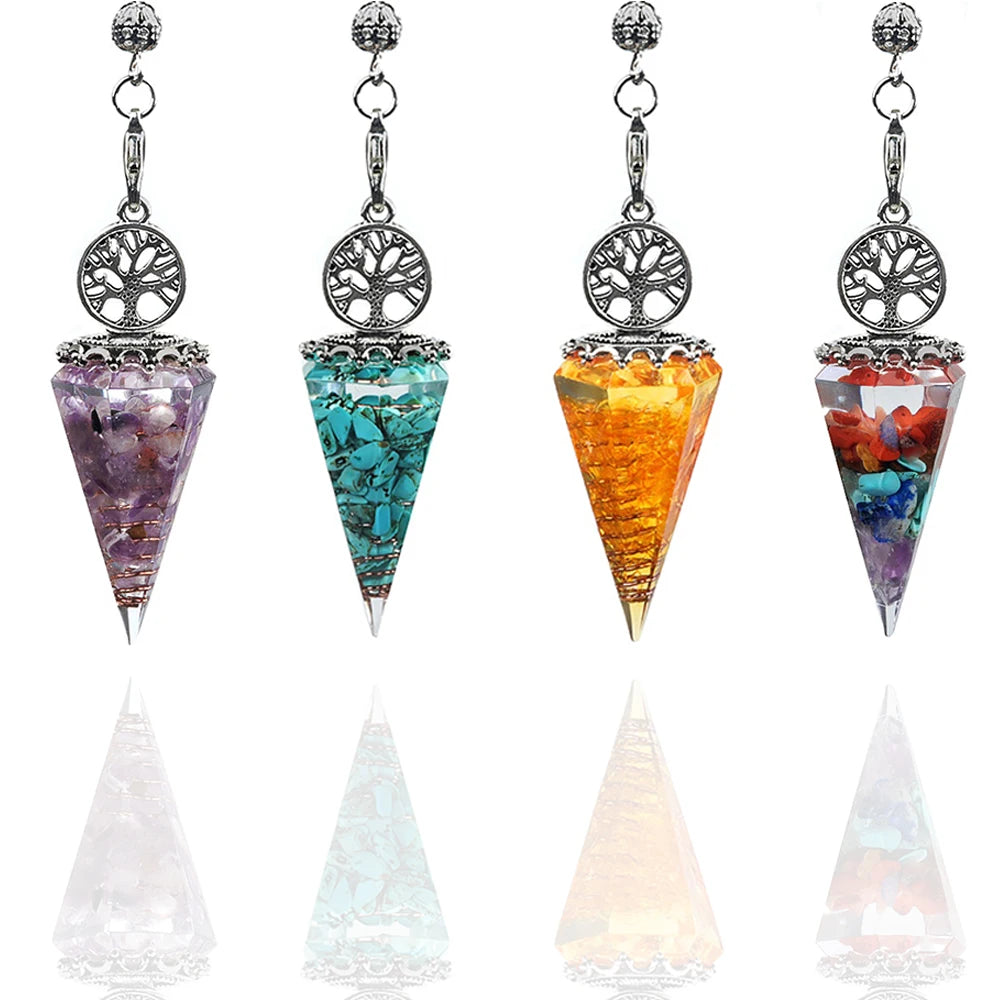 Set of four chakra stone pendulums with tree of life design on a white background