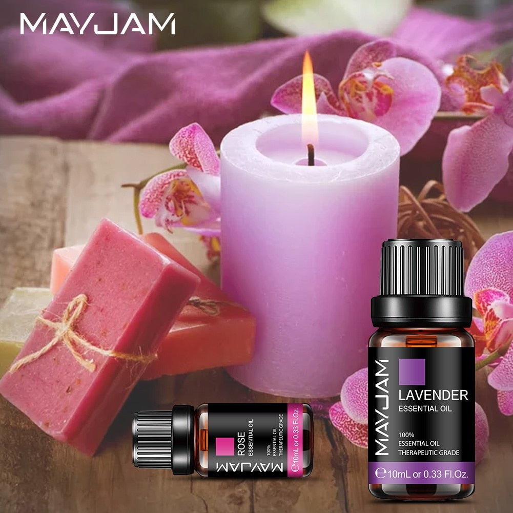 MayJam lavender candle, soap, and essential oils with pink orchids in the background