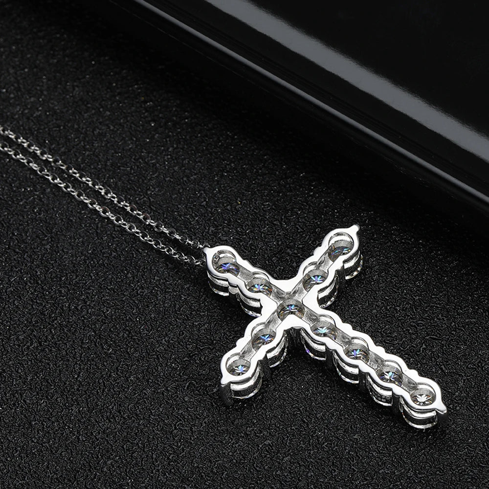 Silver cross necklace with clear stones on a black background