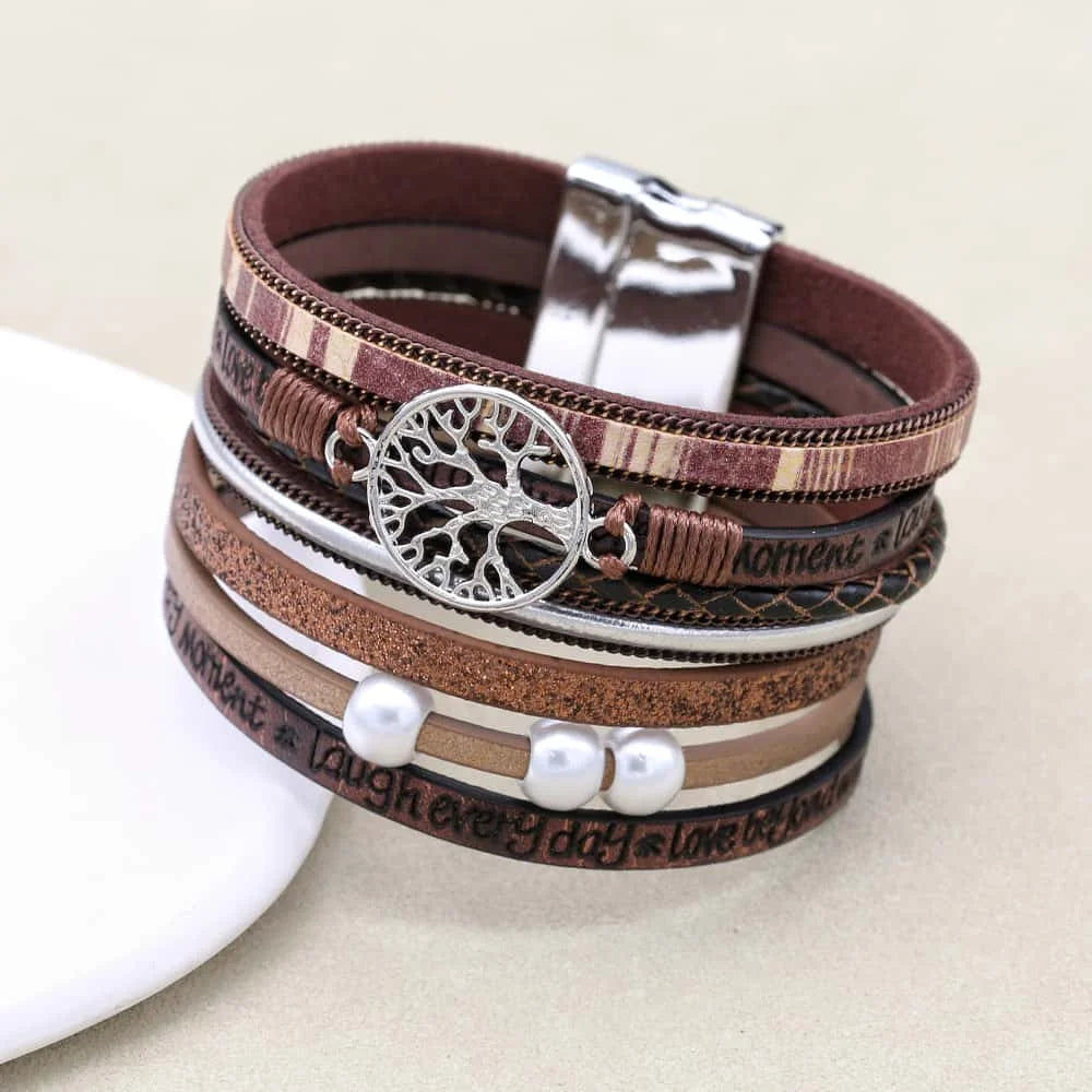 Multistrand leather bracelet with tree of life charm on a beige background