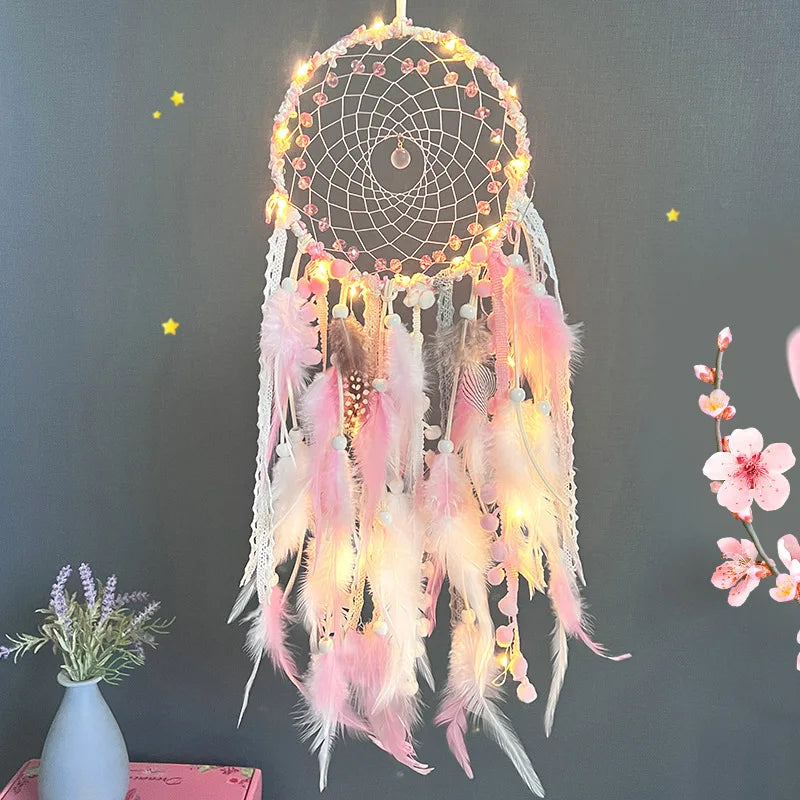 Decorative dreamcatcher with feathers and lights against a dark background