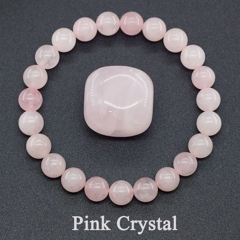 Pink crystal bracelet and stone on a dark background
