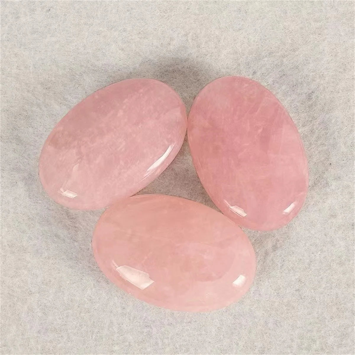 Three pink stones on a textured gray background