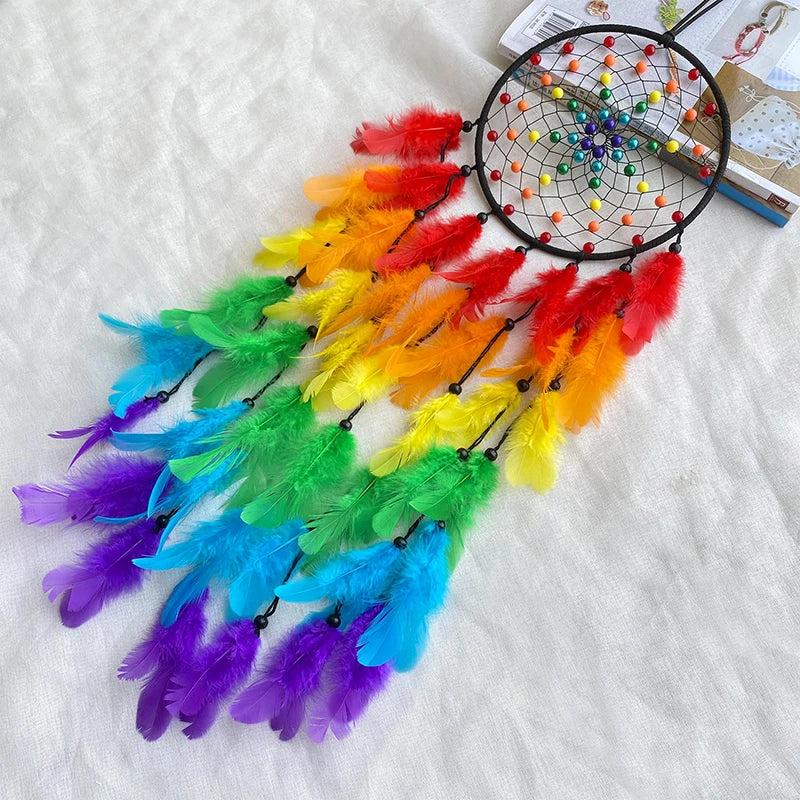 Colorful dreamcatcher with rainbow feathers on a light background