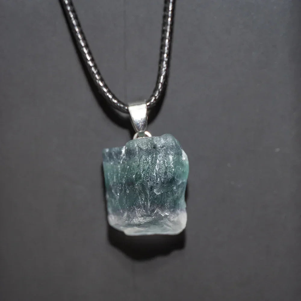 Necklace with a rough-cut gemstone pendant on a dark background
