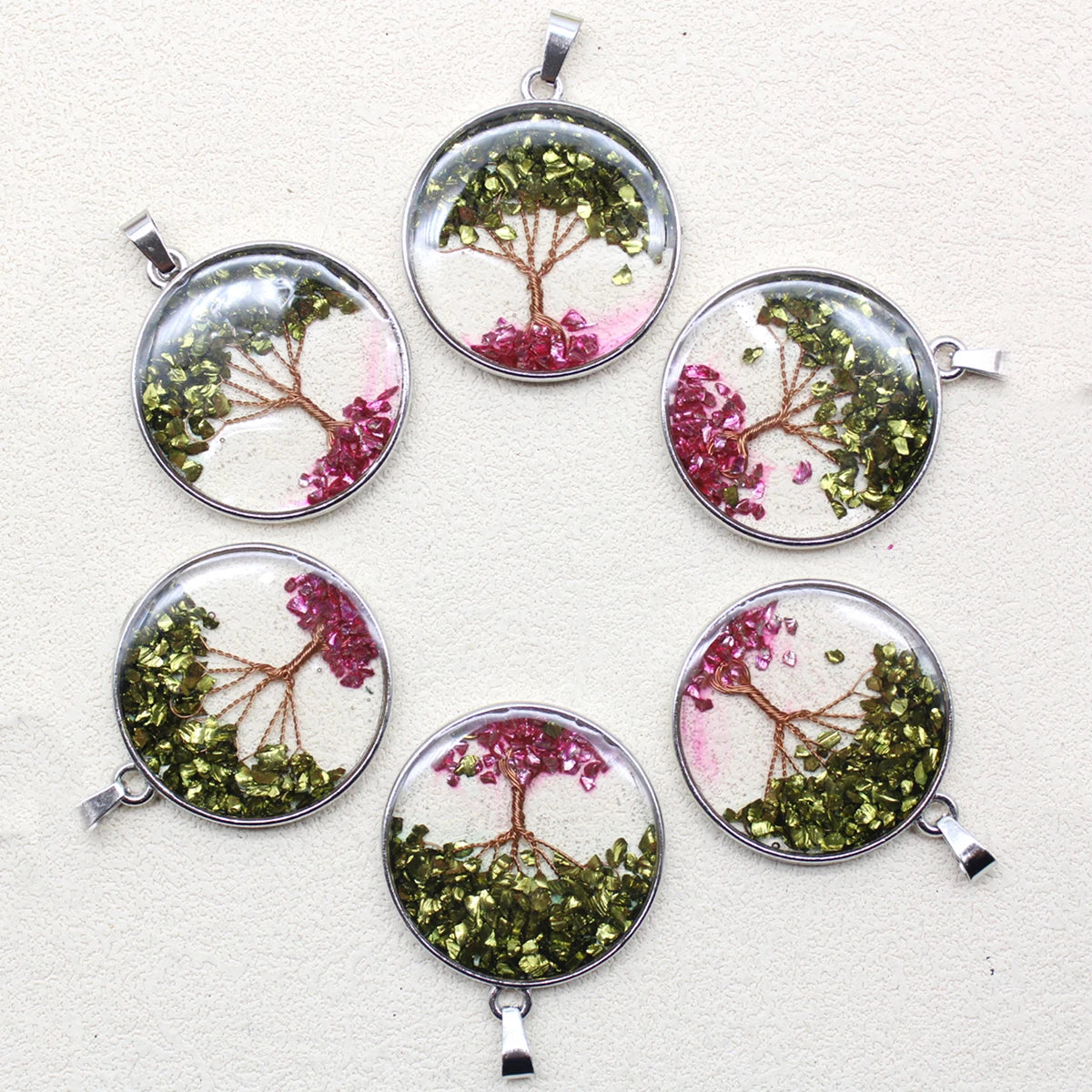 Set of six round pendants with tree designs on a light background