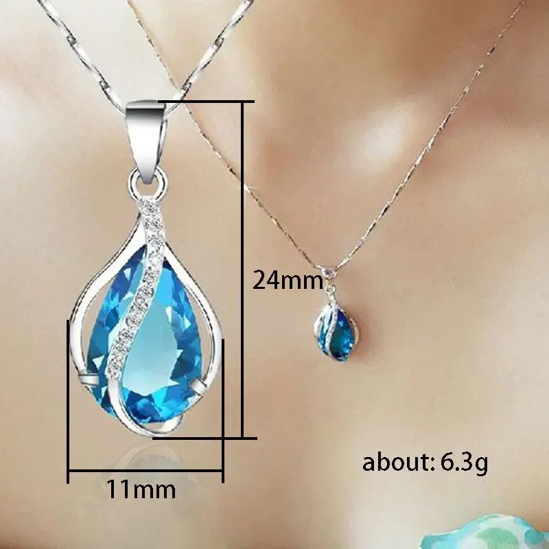 Blue teardrop pendant necklace with measurements on a neutral background