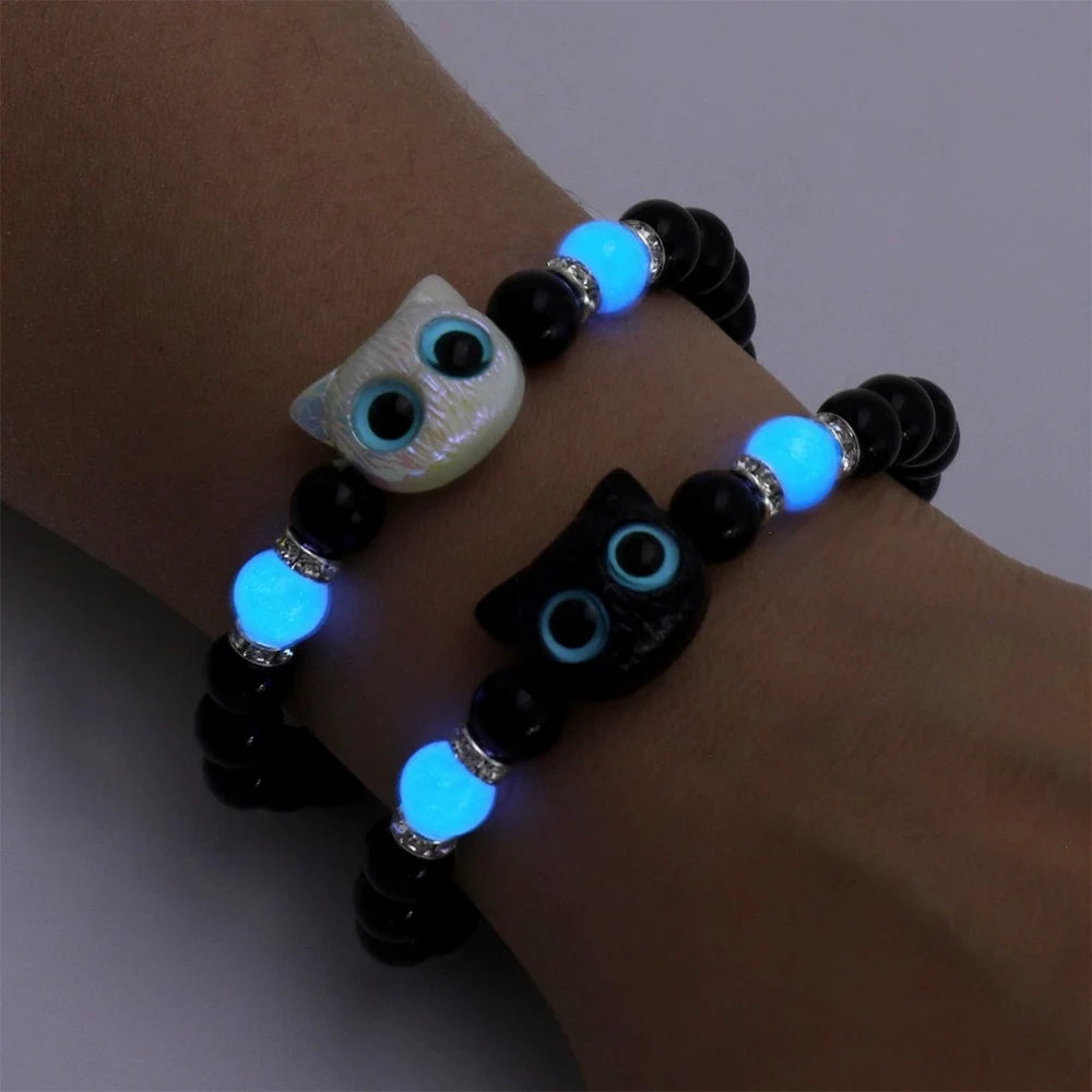 Glowing blue bracelet with owl design on a wrist against a neutral background