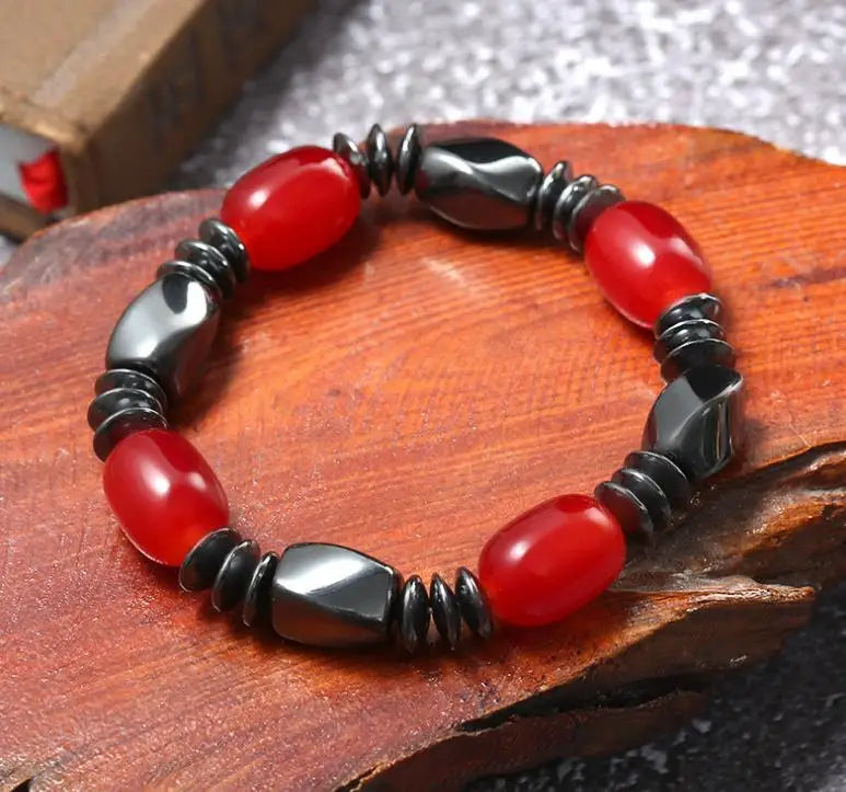 Bracelet with red and black beads on a wooden surface