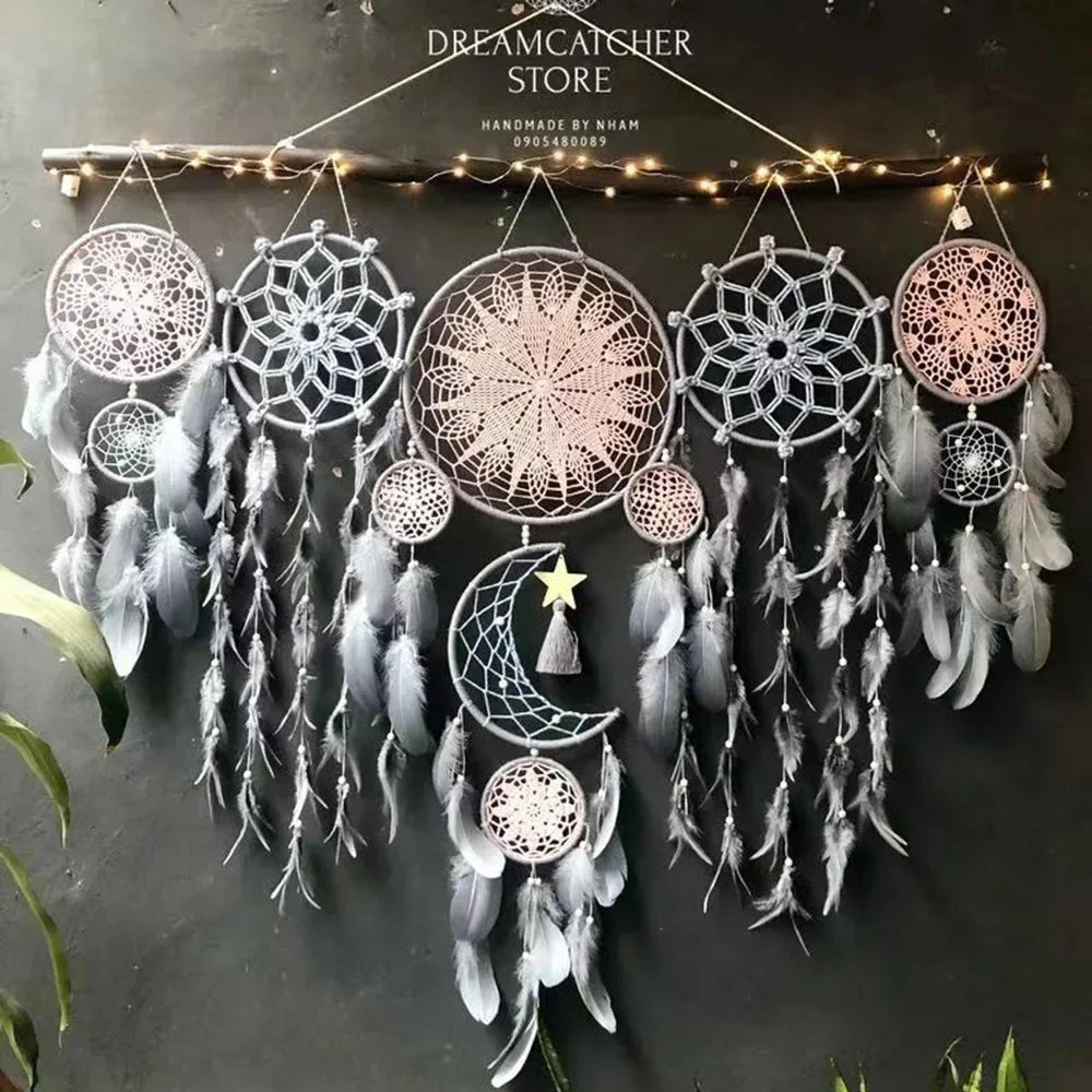 Set of dreamcatchers with feathers hanging against a dark background.