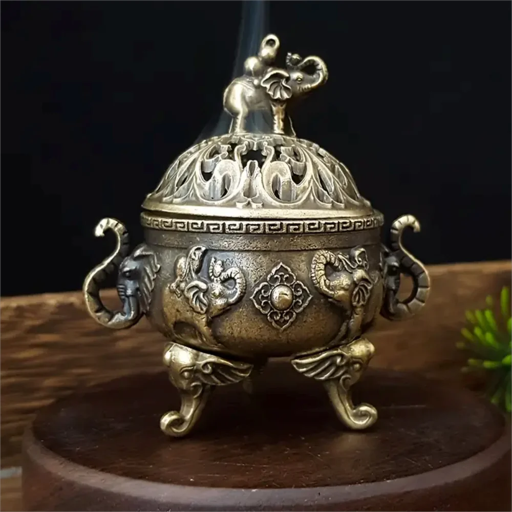 Decorative bronze incense burner with intricate designs on a dark background