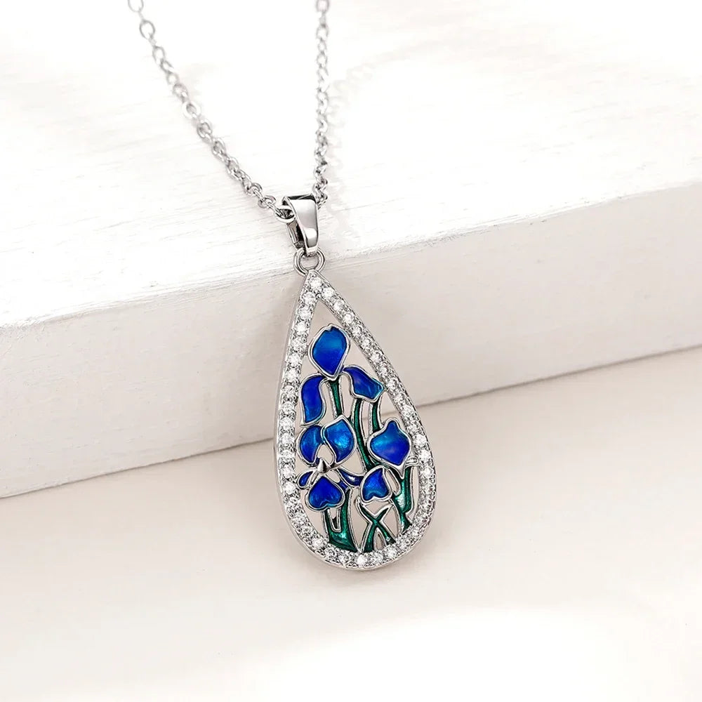 Teardrop-shaped pendant with blue floral design on a white background
