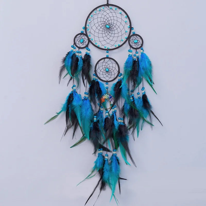 Decorative dreamcatcher with blue and black feathers on a light gray background