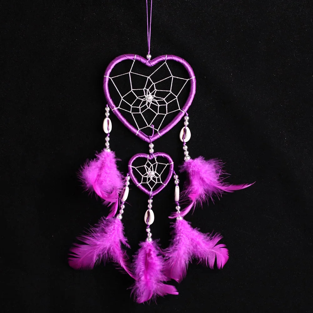 Purple heart-shaped dreamcatcher with feathers on a black background