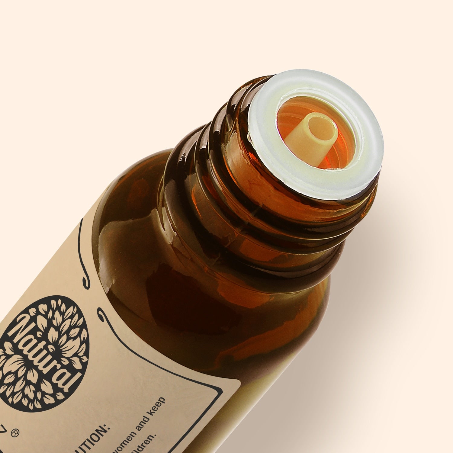 Close-up of a brown glass bottle with a white cap on a beige background