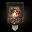 Decorative night light with tree design on a black background