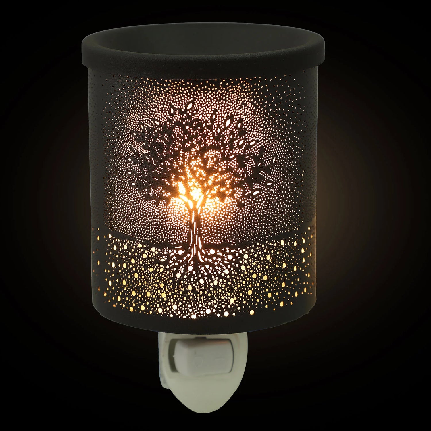 Decorative night light with tree design on a black background