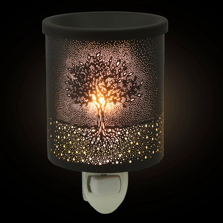 Decorative night light with tree design on a black background
