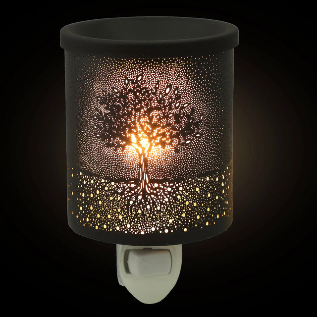 Decorative night light with tree design on a black background