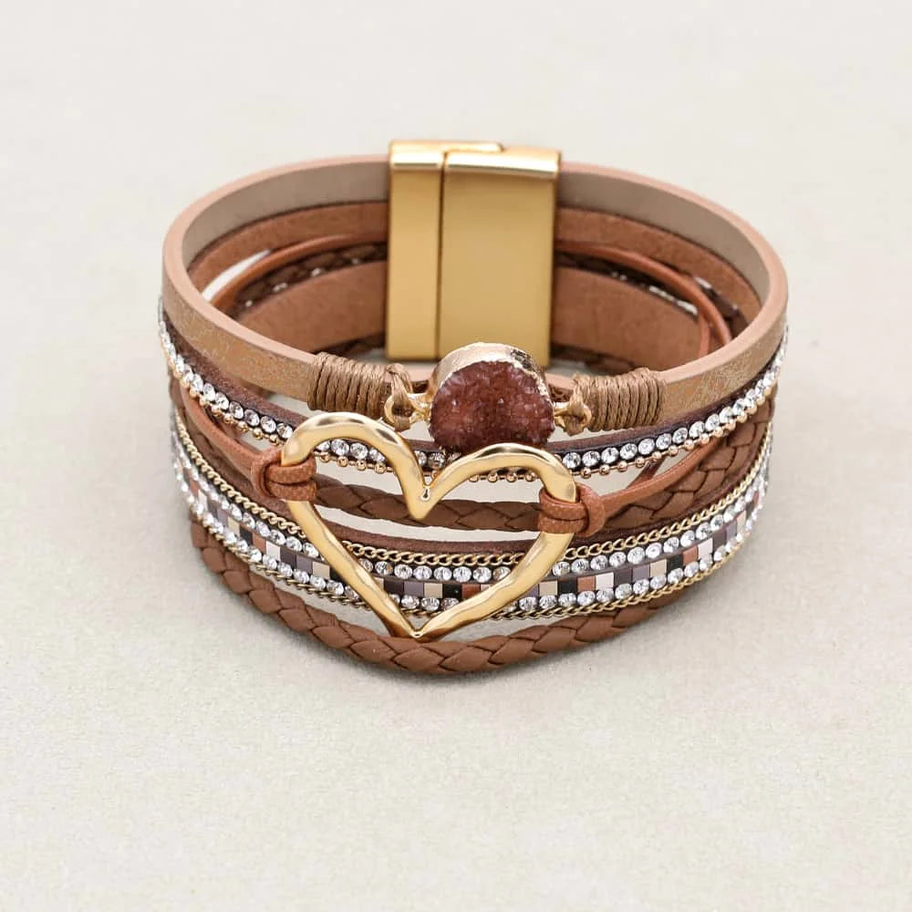 Multistrand bracelet with heart charm and gold accents on a light background