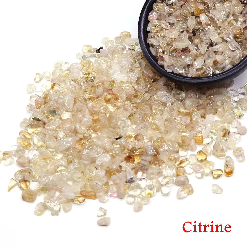 Citrine gemstones with a small bowl of them on a white background