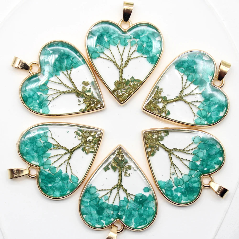 Five heart-shaped pendants with green floral designs on a white background
