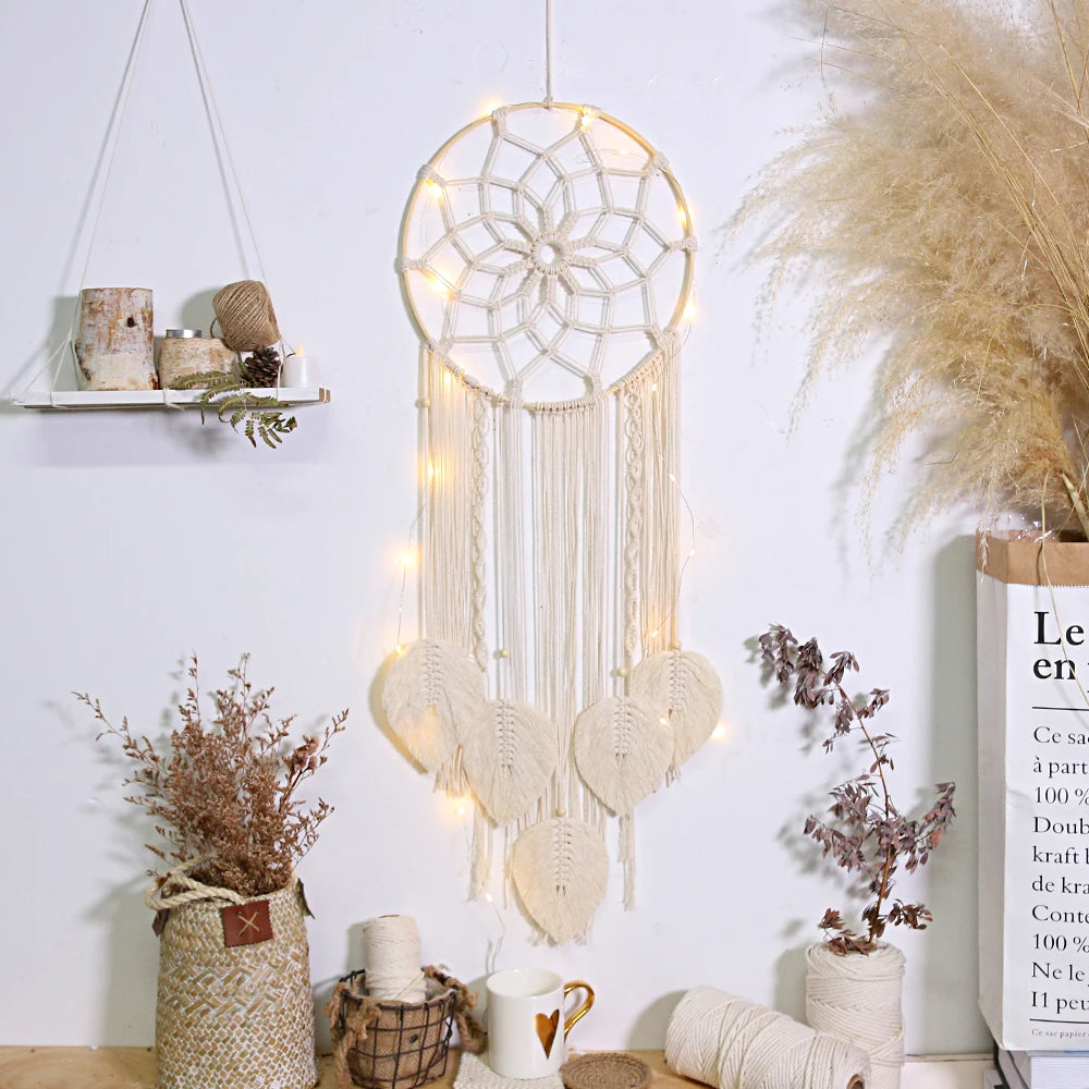 Decorative dreamcatcher with lights hanging on a wall with potted plants and a shelf.