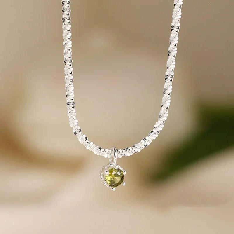 Necklace with a green gemstone pendant on a blurred background