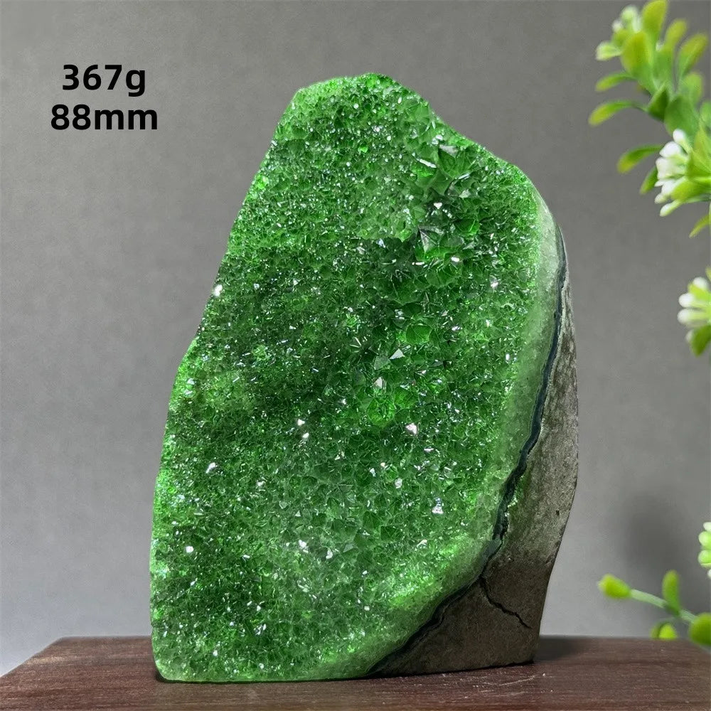 Green crystal rock on a wooden stand with a gray background