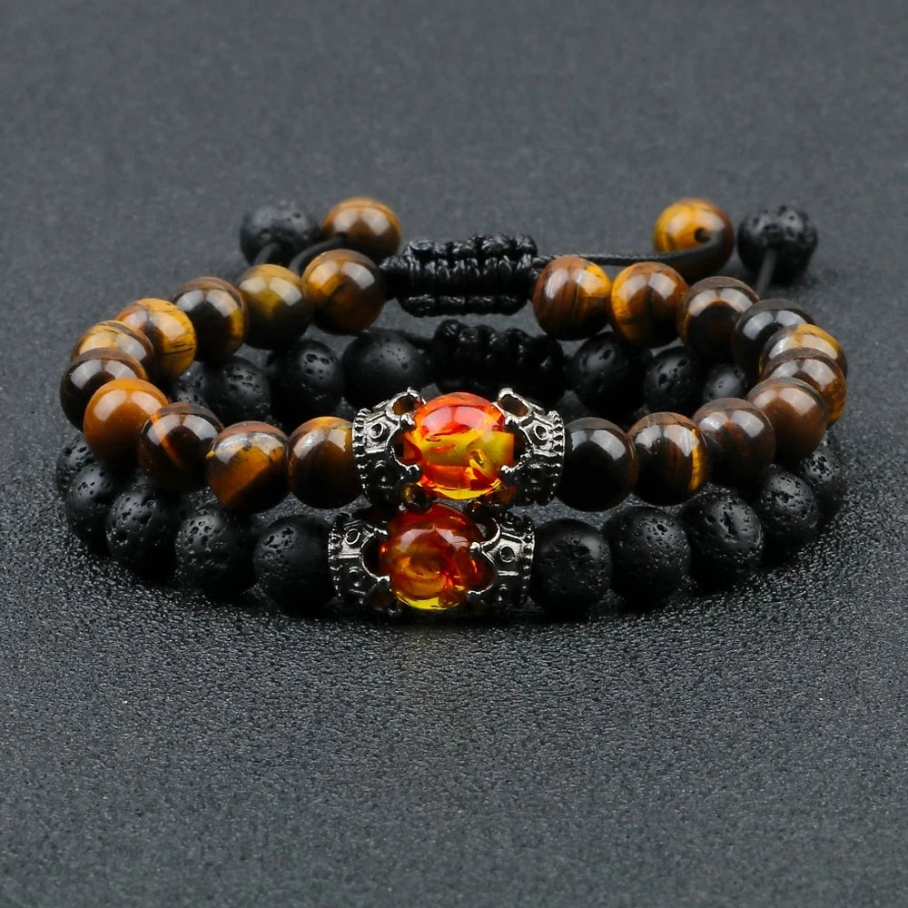 Stack of black and brown beaded bracelets with orange gemstones on a dark surface