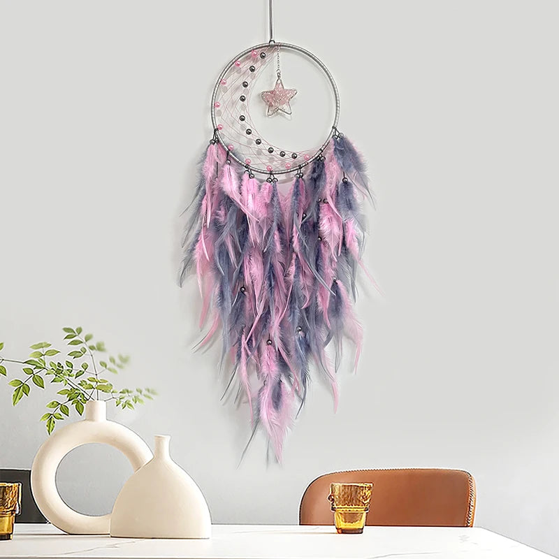 Decorative dreamcatcher with pink and purple feathers on a white wall.
