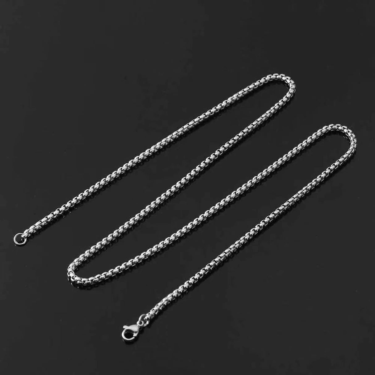 Silver chain necklace on a black background