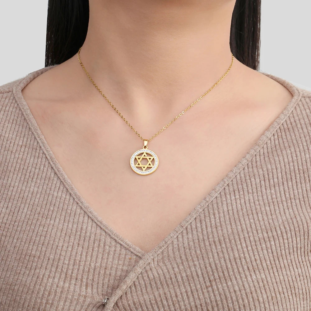Gold necklace with a Star of David pendant worn by a person in a beige sweater.