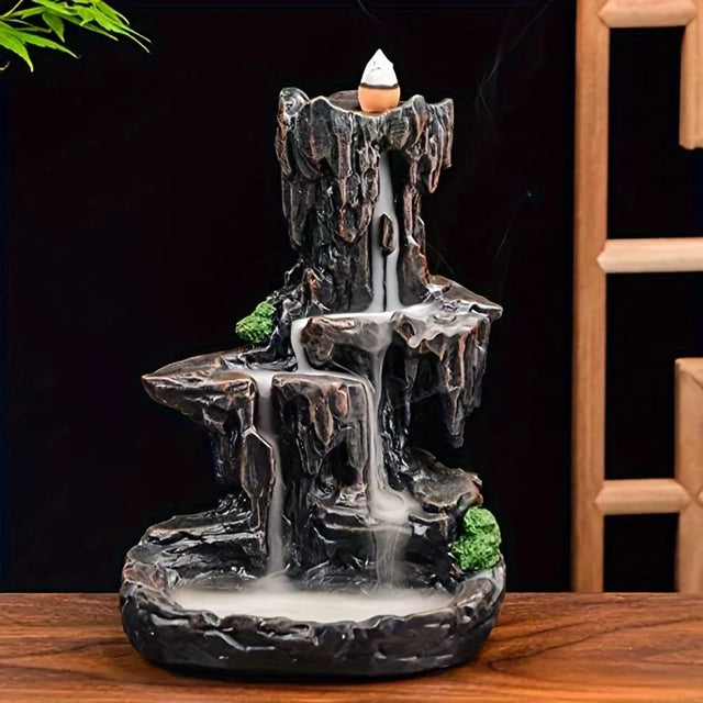 Decorative incense burner shaped like a waterfall on a wooden surface with a dark background.